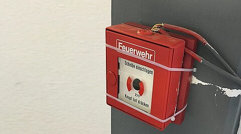 Feuermelder an der Wand mit Kabelbindern
