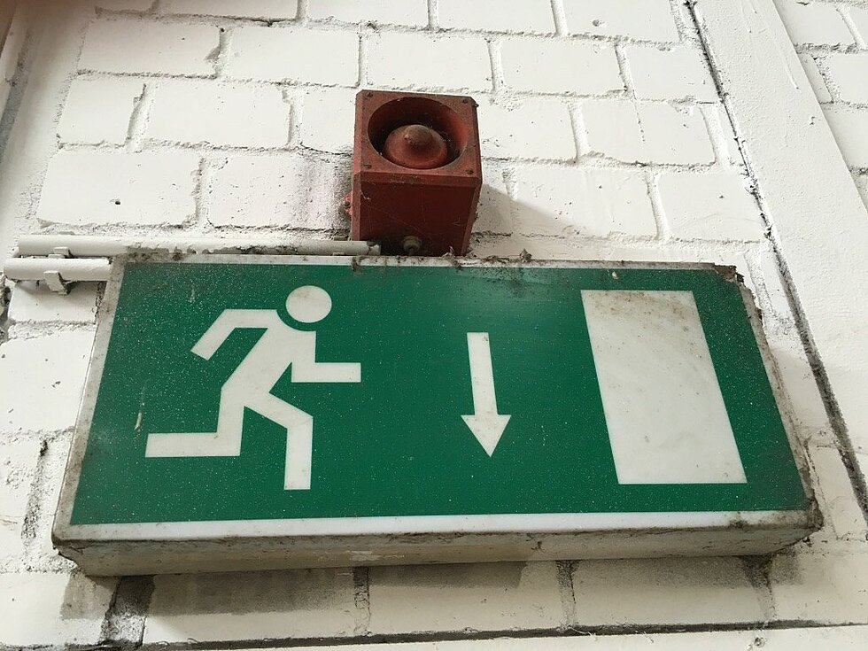 Rettungszeichenleuchte der Sicherheitsbeleuchtung an einer Wand