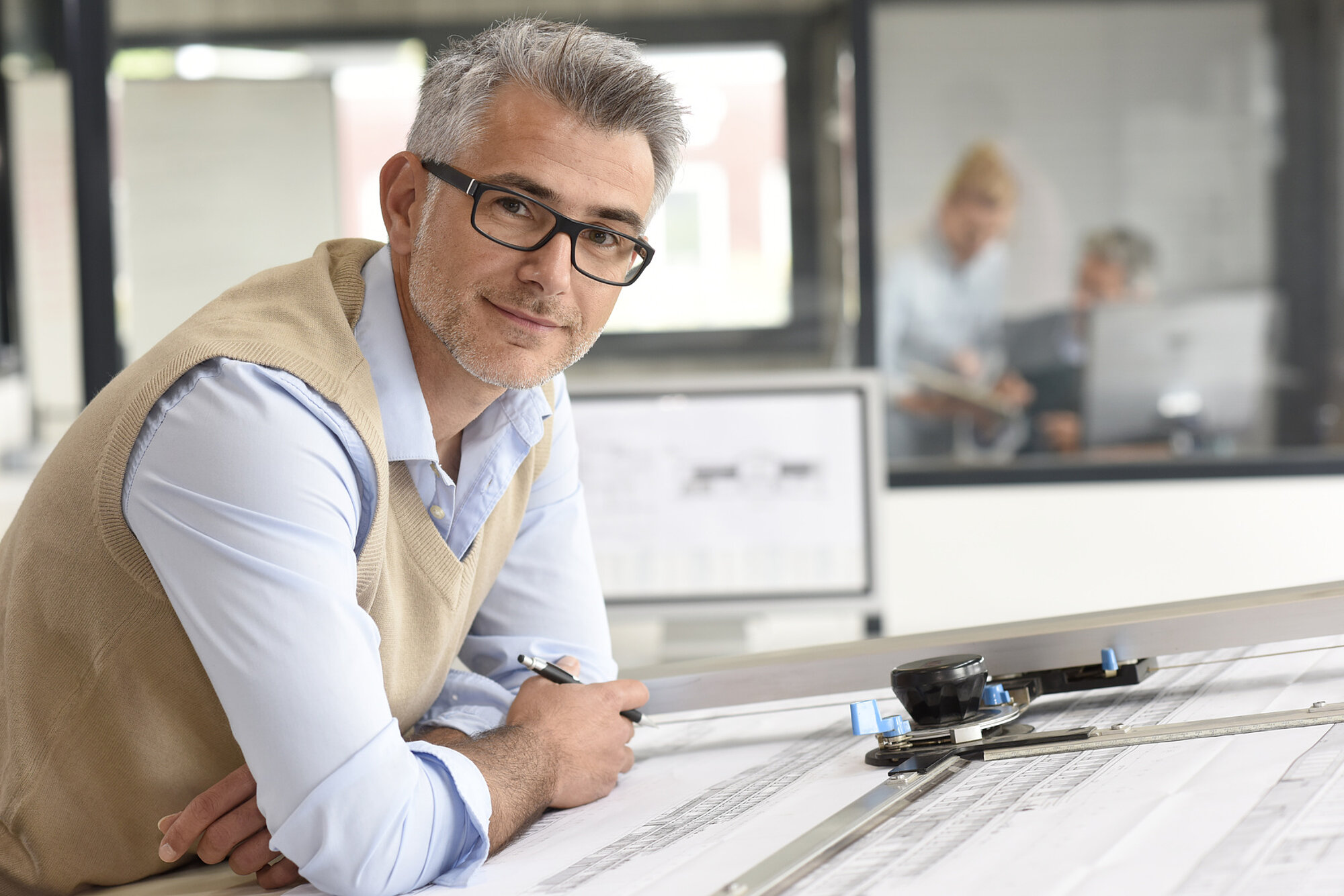 Fachplaner ISO 9001 Fachperson im Büro bei der Arbeit an Bau- oder Brandschutzplänen im Rahmen von Beratung und Projektierung